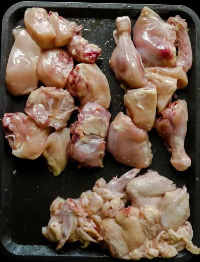 Raw, high-quality free-range Naadan Kozhi and Desi chicken pieces, showcasing firm meat texture and authentic natural fat trim, prepared fresh on a clean cutting surface.